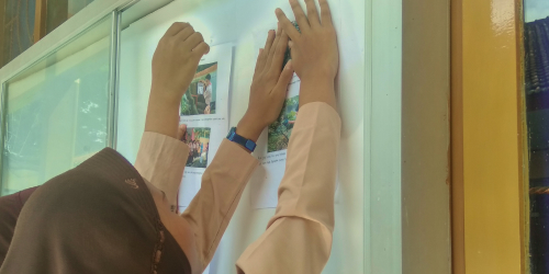 foto orang yang sedang menempel mading